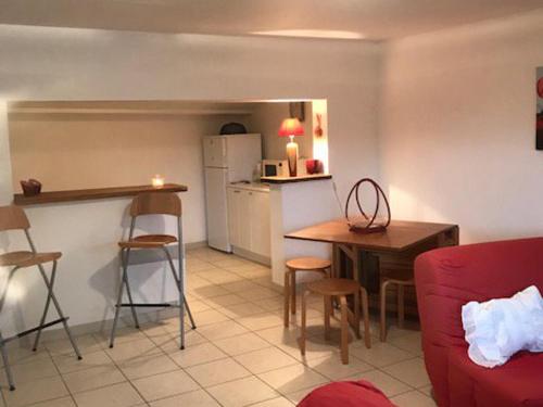 un salon avec un canapé rouge et une cuisine dans l'établissement Maison près plage Noirmoutier - Animaux admis - 4 pers - FR-1-823-131, à La Guérinière