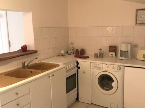 une cuisine avec un évier et une machine à laver dans l'établissement Maison près plage Noirmoutier - Animaux admis - 4 pers - FR-1-823-131, à La Guérinière