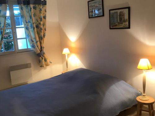 une chambre avec un lit avec deux lampes et une fenêtre dans l'établissement Maison près plage Noirmoutier - Animaux admis - 4 pers - FR-1-823-131, à La Guérinière