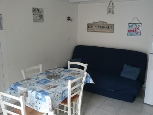 un salon avec une table et un canapé dans l'établissement Maisonnette près de la plage pour 6 pers. - FR-1-823-119, à Barbâtre