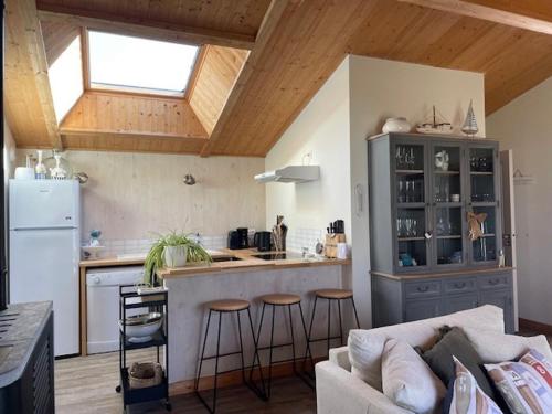 un salon avec un canapé et une cuisine dans l'établissement Maison à Barbâtre - 6 pers, jardin et WiFi - FR-1-823-132, à Barbâtre