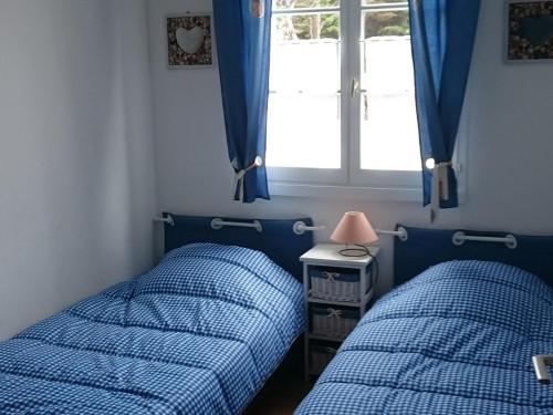 deux lits dans une chambre avec une fenêtre dans l'établissement Maisonnette près de la plage pour 6 pers. - FR-1-823-119, à Barbâtre