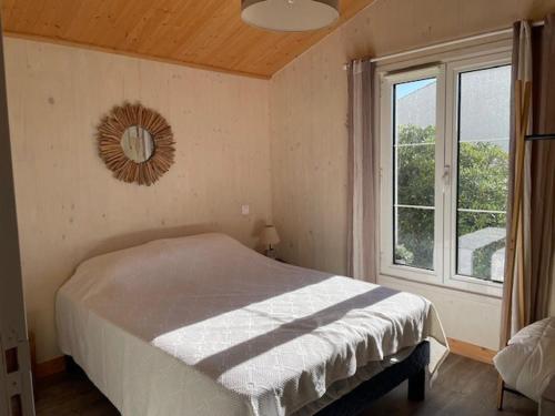 une chambre avec un lit et un miroir au mur dans l'établissement Maison à Barbâtre - 6 pers, jardin et WiFi - FR-1-823-132, à Barbâtre