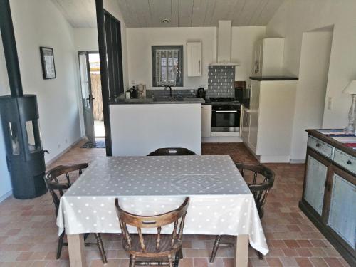 Il comprend une cuisine avec une table et des chaises. dans l'établissement Maison Plain-Pied, Proche Plage Noirmoutier, 5 Pers. - FR-1-823-133, à Noirmoutier-en-l'lle
