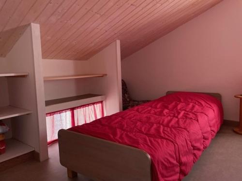une chambre avec un lit avec une couette rouge dans l'établissement Maison rénovée près de la plage pour 5 personnes à L'Épine - FR-1-823-126, à LʼÉpine