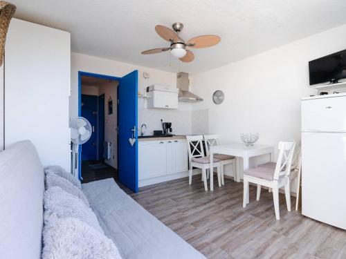 Il comprend un salon avec une cuisine et une table à manger. dans l'établissement Studio cabine avec terrasse, animaux admis, pour 4 personnes - FR-1-409A-33, à Gruissan