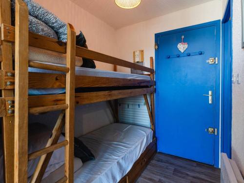 Cette chambre dispose de lits superposés avec 2 lits superposés et une porte bleue. dans l'établissement Studio cabine avec terrasse, animaux admis, pour 4 personnes - FR-1-409A-33, à Gruissan