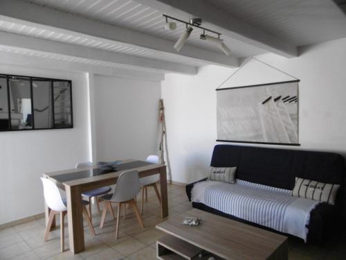 un salon avec un canapé et une table dans l'établissement Maison confortable Noirmoutier pour 4 pers, proche plage et centre - FR-1-823-123, à Noirmoutier-en-l'lle