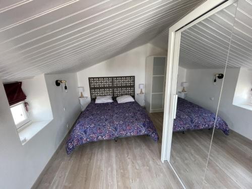une chambre avec un lit et un miroir dans l'établissement Maison confortable Noirmoutier pour 4 pers, proche plage et centre - FR-1-823-123, à Noirmoutier-en-l'lle