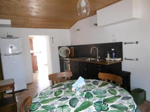 Il comprend une cuisine avec une table et un évier. dans l'établissement Maison Noirmoutier - Jardin Clos Ombre - 4 Pers - FR-1-823-136, à Noirmoutier-en-l'lle