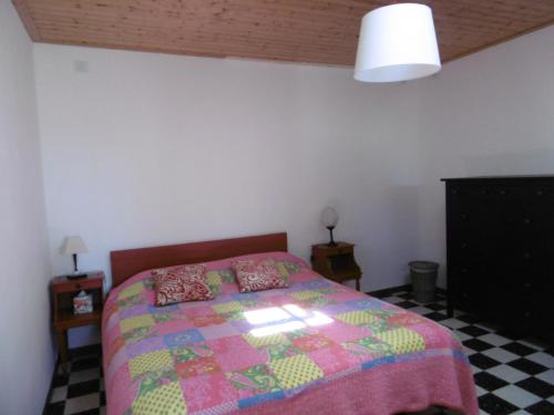 une chambre avec un lit avec une couette colorée dans l'établissement Maison Noirmoutier - Jardin Clos Ombre - 4 Pers - FR-1-823-136, à Noirmoutier-en-l'lle
