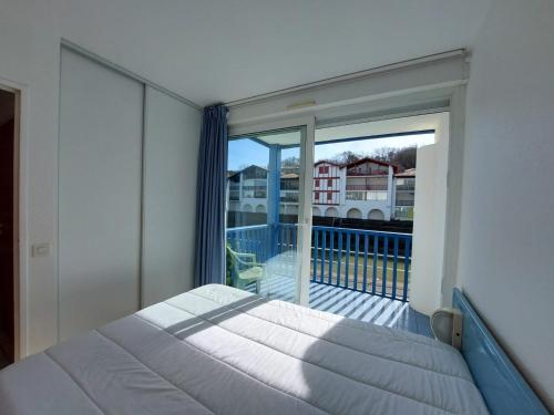 une chambre avec un lit et un balcon avec vue dans l'établissement Charmant T2 avec piscine à 2 min de la plage - FR-1-239-1104, à Urrugne