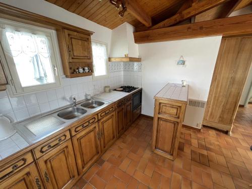 une cuisine avec des armoires en bois et un évier dans l'établissement Maison calme Noirmoutier Plage Sableaux, Animaux admis - FR-1-823-134, à Noirmoutier-en-l'lle