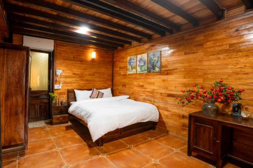 a bedroom with a bed in a wooden room at Mế farmstay in Cao Bằng