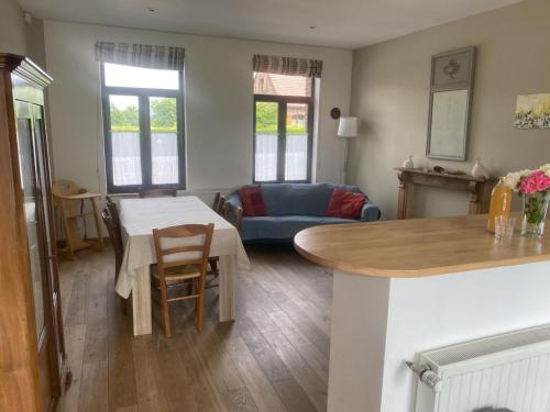 une cuisine et un salon avec une table et un canapé dans l'établissement Gîte champêtre avec jardin privé, animaux admis - FR-1-510-231, à Rumegies