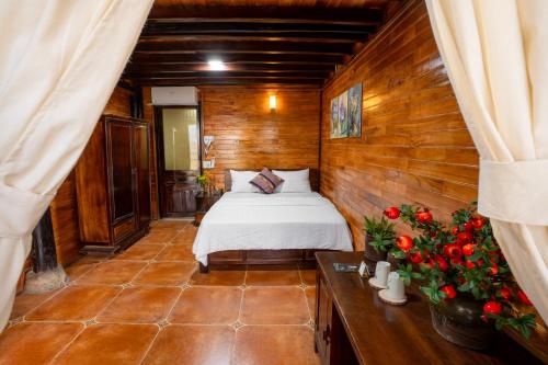 a bedroom with a bed and flowers in a room at Mế farmstay in Cao Bằng