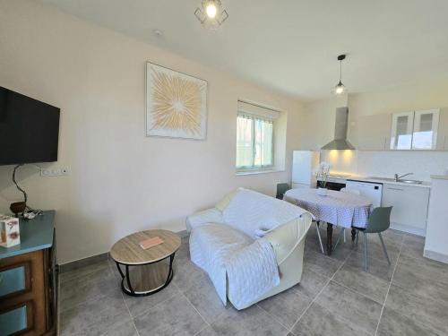 un salon avec un canapé et une table dans l'établissement Le petit Nid d'Eugénie - Havre en Campagne, Animaux Bienvenus - FR-1-616-467, à Génis