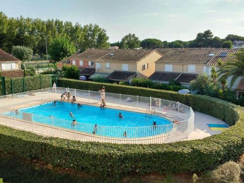 une vue aérienne d'une piscine avec des gens dedans dans l'établissement Appt climatisé, 4 pers, piscine et parking - Le Grau-du-Roi - FR-1-250-300, au Grau-du-Roi