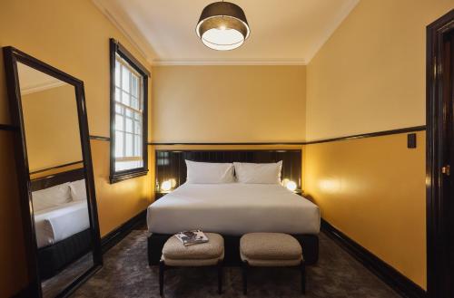 a bedroom with a large bed and a mirror at Hotel Diplomat Sydney in Sydney