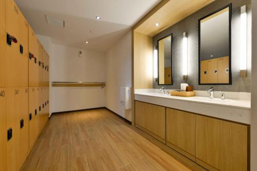a bathroom with two sinks and a large mirror at Hotel Nikko Amata City Chonburi in Chon Buri