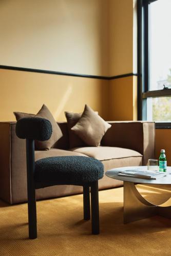 a living room with a couch and a chair and a table at Hotel Diplomat Sydney in Sydney
