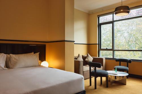 a hotel room with a bed and a table at Hotel Diplomat Sydney in Sydney