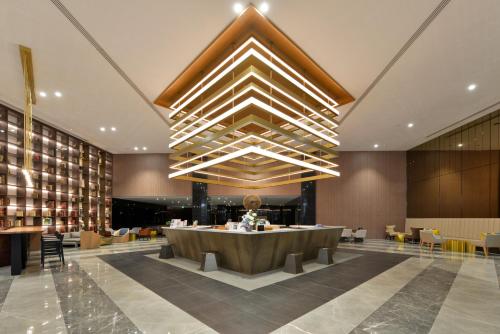 a lobby with a large table in a building at Hotel Nikko Amata City Chonburi in Chon Buri