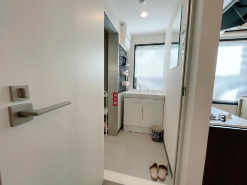 a bathroom with a sink and two pairs of shoes at --New--南町駅徒歩1分-ビル2階-貸切ルーム8人まで-松山城や道後温泉へアクセス良好-駐車場無料 in Matsuyama