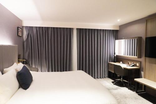 a hotel room with a bed and a desk at Crowne Plaza London - Kingston by IHG in Kingston upon Thames