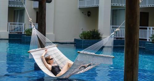 a woman laying in a hammock in a pool at Sofitel Krabi Phokeethra Golf and Spa Resort in Klong Muang Beach