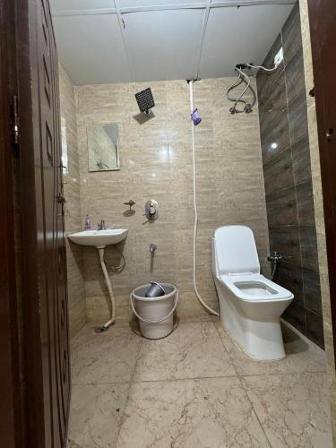 a bathroom with a toilet and a sink and a shower at Hotel Elite Enclave in Hyderabad