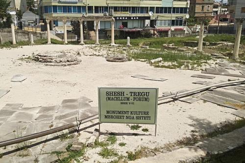 a sign in the middle of a courtyard with a building at Backpackers Casa De Payaso in Durrës