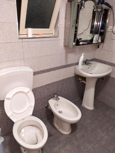 a bathroom with a toilet and a sink at Backpackers Casa De Payaso in Durrës