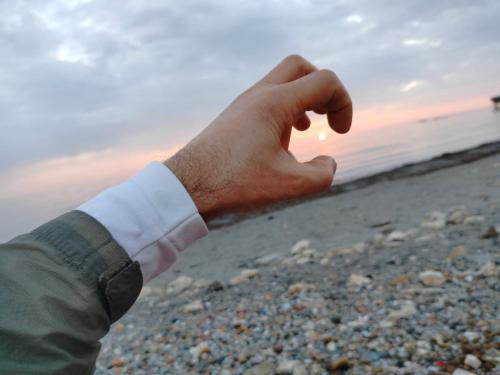 a person holding their hand out on the beach at Backpackers Casa De Payaso in Durrës