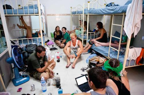 a group of people sitting in a room with bunk beds at Backpackers Casa De Payaso in Durrës