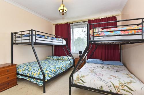 a bedroom with two bunk beds and a dresser at Coal d' Vine Entertainer - Cessnock NSW in Cessnock