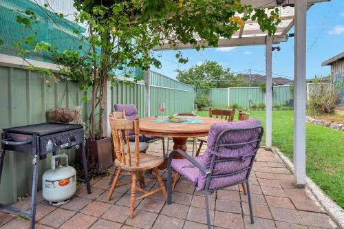 a patio with a table and chairs and a grill at Coal d' Vine Entertainer - Cessnock NSW in Cessnock