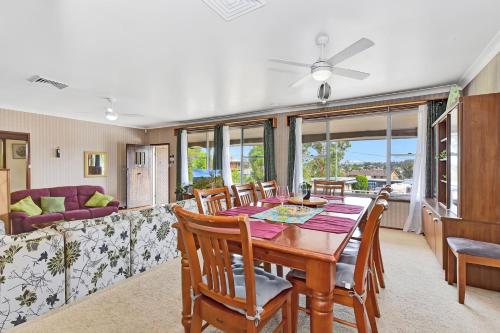 a dining room with a table and chairs and a couch at Coal d' Vine Entertainer - Cessnock NSW in Cessnock