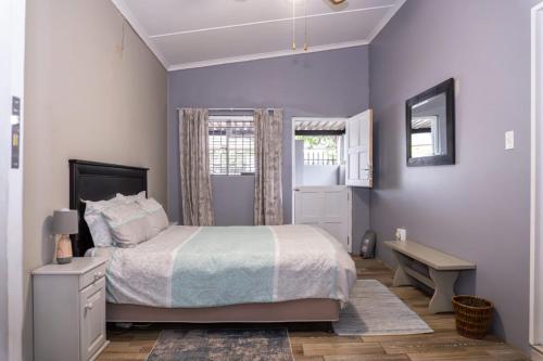 a bedroom with a bed and a desk and a window at AVONDBLIJ Apartment in Oudtshoorn