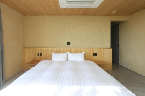 a bedroom with a large bed with two pillows at KITOW private villa in Awaji