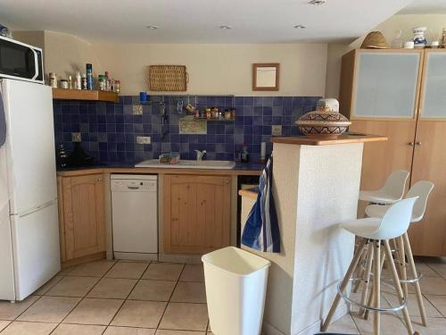 a kitchen with a white refrigerator and blue tiles at F2 Climatisé Proche Cures, Amélie-les-Bains - FR-1-703-208 in Amélie-les-Bains-Palalda