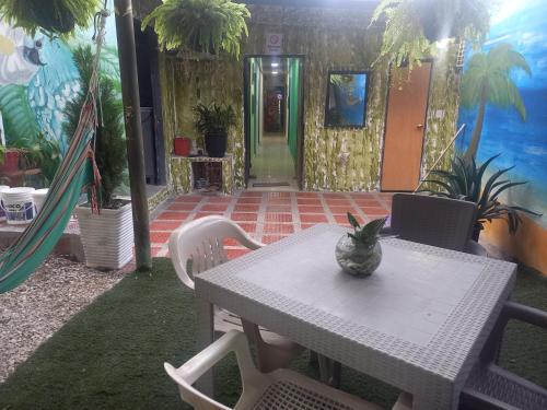 una mesa y sillas con un jarrón encima en Casa alojamiento las acacias, en Santa Marta
