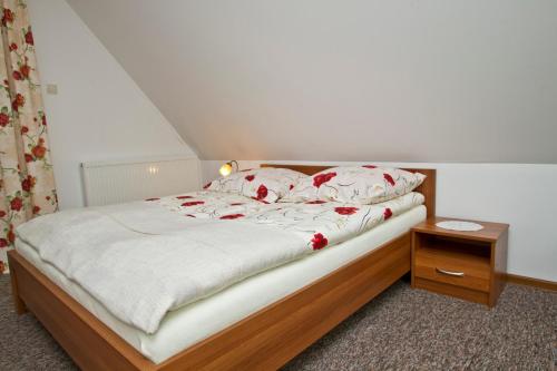 a bedroom with a bed with red flowers on it at Willa Bystra in Kościelisko