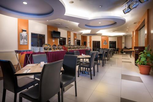 クアラルンプールにあるHotel Sentral KL @ KL Sentral Stationのレストラン内のテーブルと椅子のあるダイニングルーム
