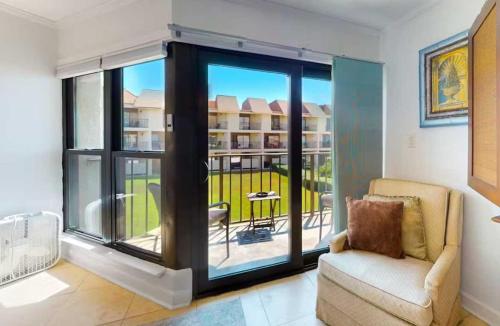 ein Wohnzimmer mit einem Stuhl und einem großen Fenster in der Unterkunft Gulfside Townhome 6 townhouse in Gulf Shores