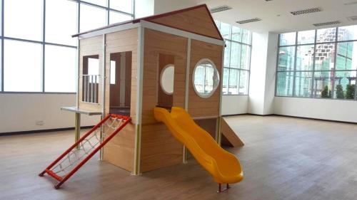 a playroom with a slide and a play house at Silverscape Seaview Residence Melaka in Melaka
