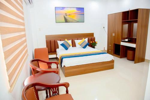 a bedroom with a bed and a desk and a chair at GIA BẢO HOTEL 1116 Huỳnh tấn phát in Ho Chi Minh City