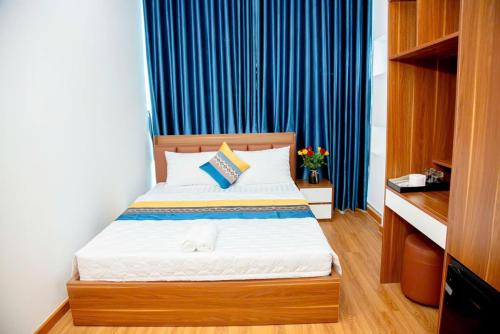 a bedroom with a bed with a blue curtain at GIA BẢO HOTEL 1116 Huỳnh tấn phát in Ho Chi Minh City