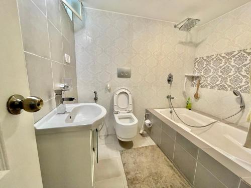 a bathroom with a toilet and a tub and a sink at Bell Villa Luxury 3BHK Private Home Stay with Garden perfect for Families Couples Staycations in Kodaikānāl