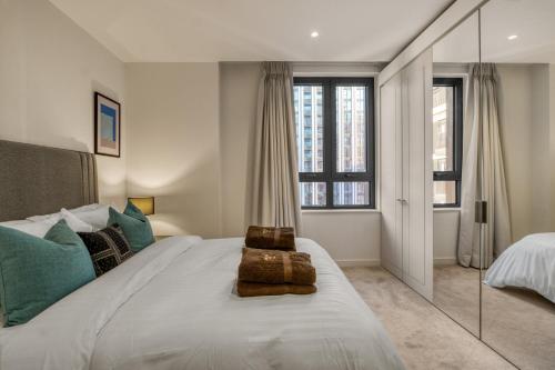 a bedroom with a large white bed with a mirror at Hyde Park Beauty 2BR 2BA Balcony in London